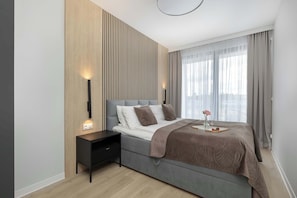 Una camera da letto moderna con un letto, un comodino e una abat-jour.