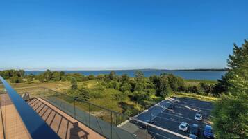 A parking area with a view of a body of water and trees.