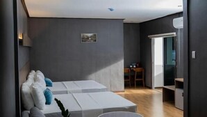 A modern living room with a sofa, a small round table, and a large window. - Adela Resort Panglao (Panglao)