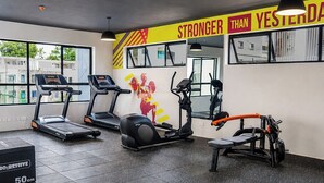 Una palestra con tapis roulant, ellittiche e una panca.