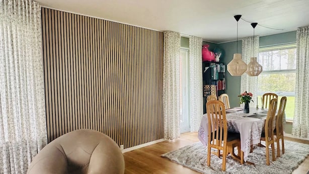 A dining area with a round bean bag chair, wooden chairs, a table with a white tablecloth, and a bookshelf with books and a pink stuffed toy. - Room-family Private House (Brovst)
