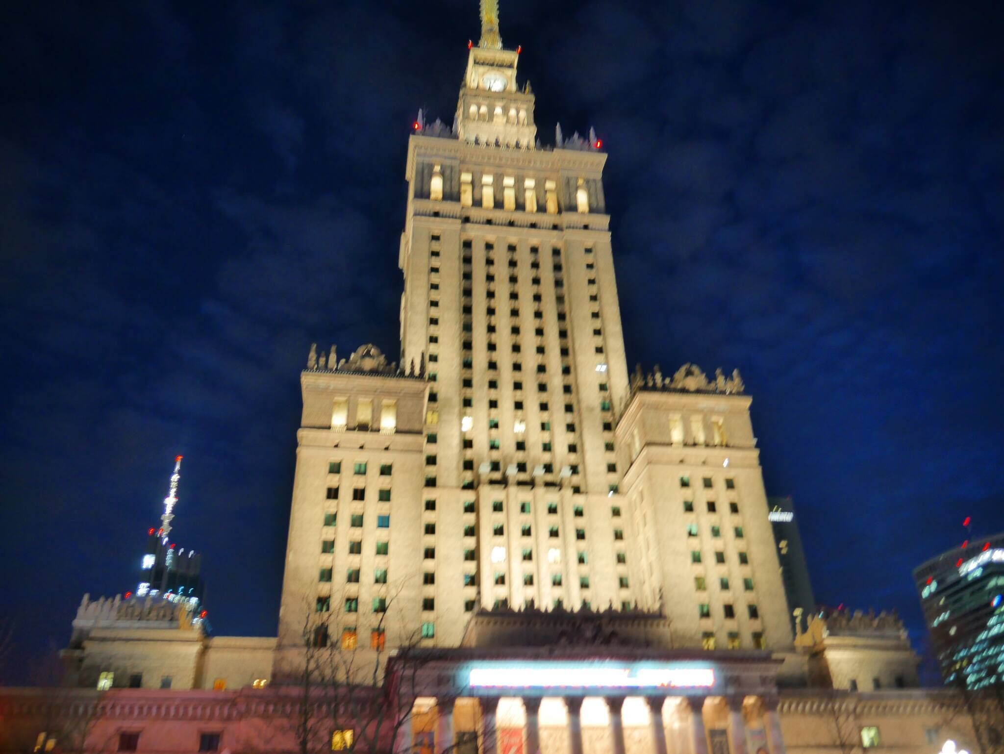 A large, multi-story building with a prominent central tower and multiple windows.