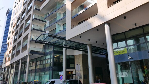 A multi-story building with a glass facade, large windows, and a covered entrance area. - Designer 1BR Luxury Retreat in Center of Warsaw (Warsaw)