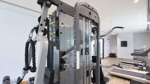 Ein Fitnessstudio mit einem Mehrzweck-Kraftgerät, Laufbändern und einer Trainingsbank.