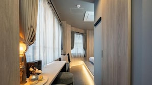 Een smalle gang met een eethoek, inclusief een tafel en stoelen, een kleine decoratieve vaas en een wandlamp.