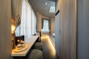 A narrow hallway with a dining area featuring a table and chairs, a small decorative vase, and a wall-mounted light fixture. - JAPAVISTA Vita (BENTEN, MINATO WARD)