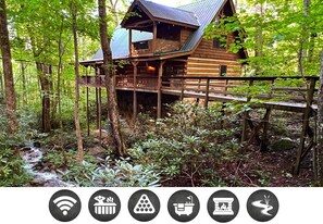 Une cabane en bois dotée d’un balcon, entourée d’une forêt.