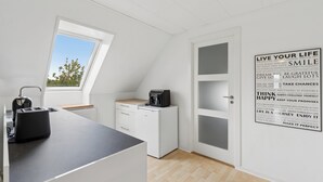 Cocina moderna con ventana, tostadora, cafetera y una pared con citas motivacionales.