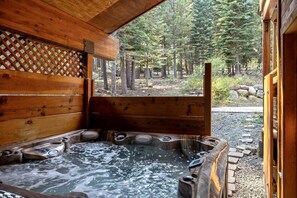 A wooden cabin with a hot tub and a view of a forest. - Luxury Cabin with a Private Hot Tub in Tahoe Donner, California (Truckee)