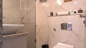 A bathroom with a marble sink, a shower with a glass door, and a toilet. - 3BR Borderman's Retreat in center with cook (Jaipur)