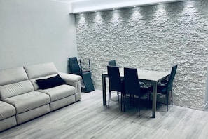 Ein modernes Wohnzimmer mit einer Couch, einem Esstisch und Stühlen.