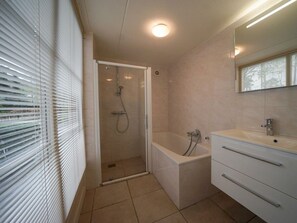 A bathroom with a shower, a bathtub, a sink, and a mirror. - Villa in Beekbergen With Terrace (Beekbergen)