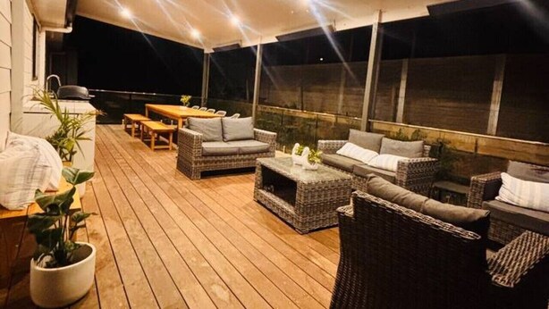 An outdoor patio with wicker furniture, a table, and potted plants. - Meadow Lees - Linen, Wi-Fi, Pet Friendly (Venus Bay)