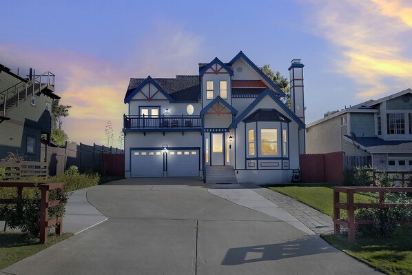 A two-story house with a garage, a balcony, and a chimney.
