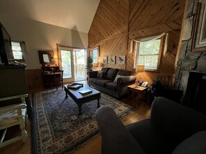Ein gemütliches Wohnzimmer mit Kamin, einer Couch, einem Couchtisch und einem Teppich.
