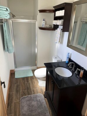 A bathroom with a shower, toilet, sink, and a towel rack. - Charming, Glamping Cabin with Barbecue Grill, Perfect for Wildlife Watching in Raton, New Mexico (Raton)