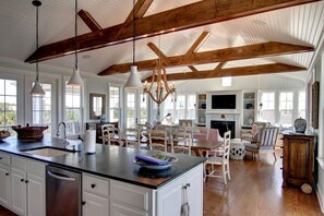 A spacious kitchen with a large island, wooden beams, and pendant lighting. - Vacation Rental for Families with Access to Pool and Tennis Courts in Holden Beach, North Carolina (Holden Beach)