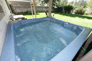 Un bain à remous de forme rectangulaire et à surface texturée.