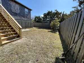 Ein Garten mit einer Holztreppe, einem Holzzaun und einem Haus im Hintergrund.