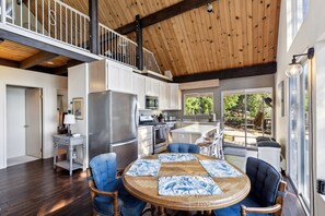 Una cocina amplia con electrodomésticos modernos, un comedor con mesa redonda y vistas al exterior.
