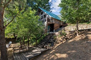 A cabin with a metal roof, wooden stairs, and a deck area. - Charming A-Frame with Stunning Views in Kelseyville, California (Kelseyville)