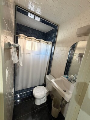 Habitación individual estándar | Baño | Regadera, toallas, jabón, shampoo 
