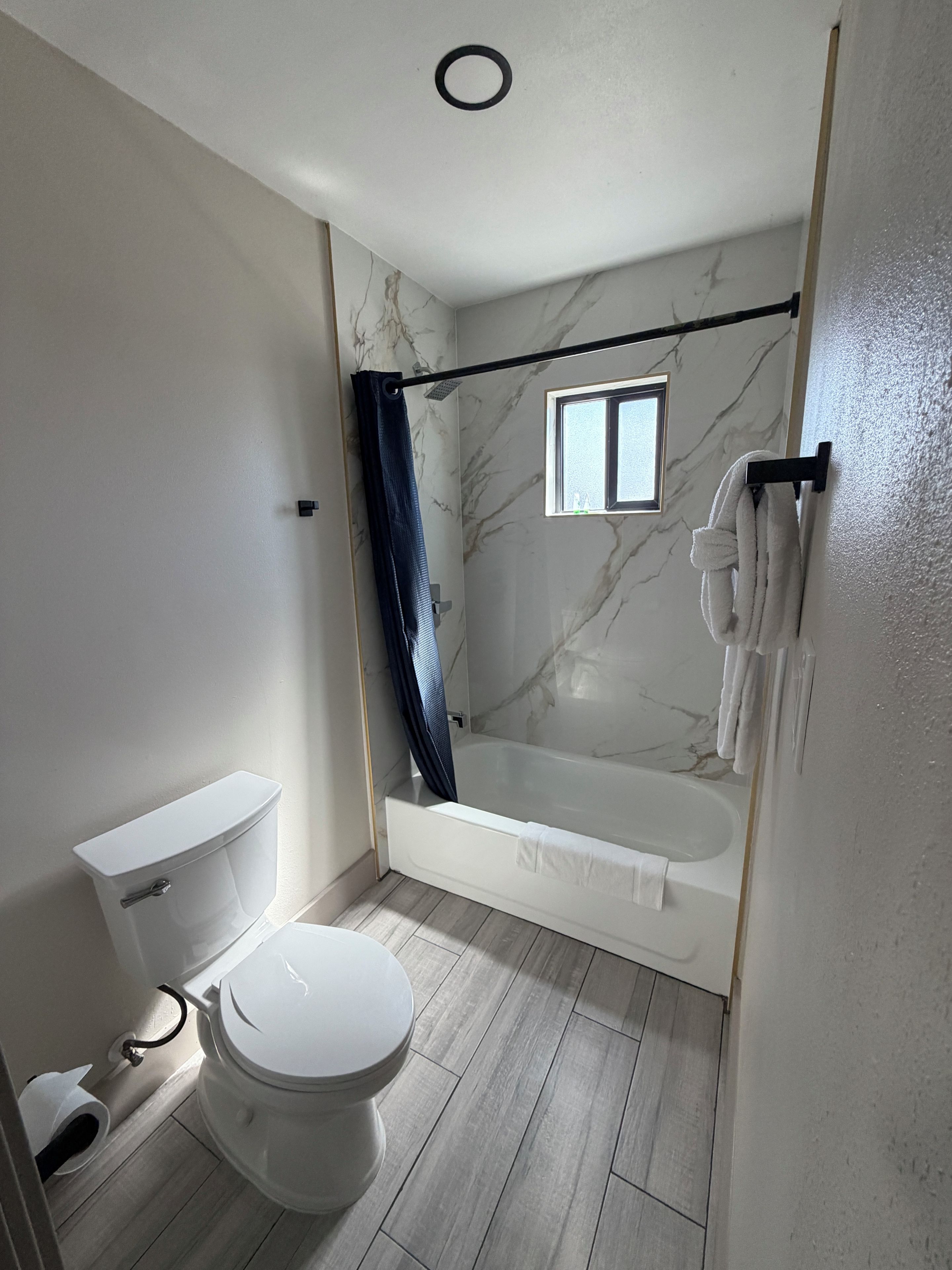A bathroom with a toilet, a bathtub, and a shower curtain.