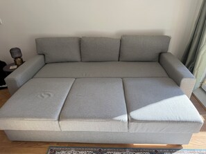 A grey sectional sofa with a wooden floor and a patterned rug. - Spacious Didsbury Stay | Sleeps 6 | Free Parking (Manchester)