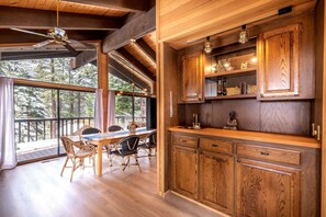 A wooden interior with a dining area, large windows, and built-in wooden cabinets. - Spectacular Cabin with Foosball and Fireplace in Truckee, California (Truckee)