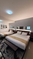 Una habitación de hotel con dos camas, un espejo grande y un piso con diseño de mármol.