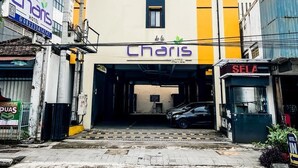Ein Hotel mit gelb-weißer Fassade, einem gut sichtbaren Eingang und einem geparkten Auto davor.