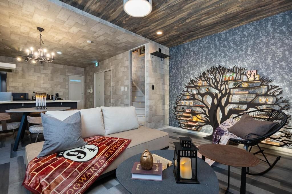 A modern living room with a sofa, a coffee table, a bookshelf, and a dining area with a table and chairs.