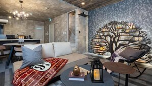 Una sala de estar moderna con un sofá, una mesa de centro, una estantería y un comedor con mesa y sillas.