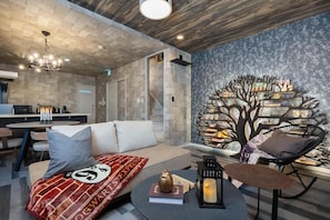 A modern living room with a sofa, a coffee table, a bookshelf, and a dining area with a table and chairs. - JAPAVISTA Enchant (NISHIKUJŌ, KONOHANA WARD)