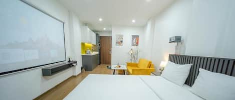 A hotel room with a bed, a desk, a chair, and a small table.