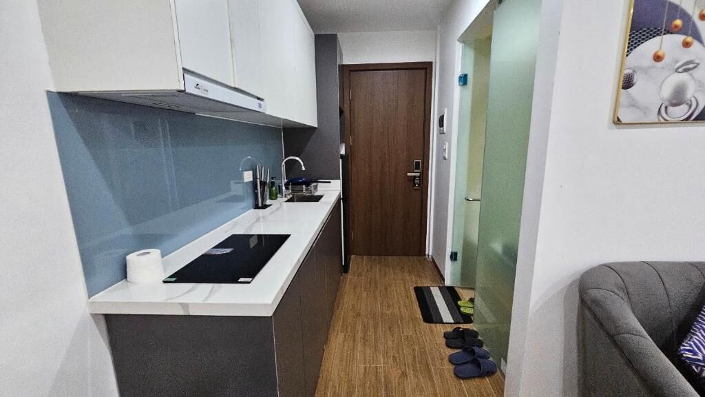 A compact kitchen with a countertop, sink, and a door leading to another room.