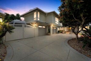A two-story house with a garage, a driveway, and a well-maintained garden.