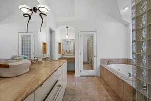 A spacious bathroom with a large vanity, a bathtub, and a walk-in shower.