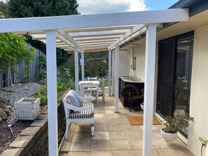 A covered patio area with a white chair, a table, and a potted plant. - Relax & unwind on the Gold Coast (Reedy Creek)