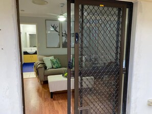 A living room with a sofa, a coffee table, and a decorative wall piece. - Relax & unwind on the Gold Coast (Reedy Creek)