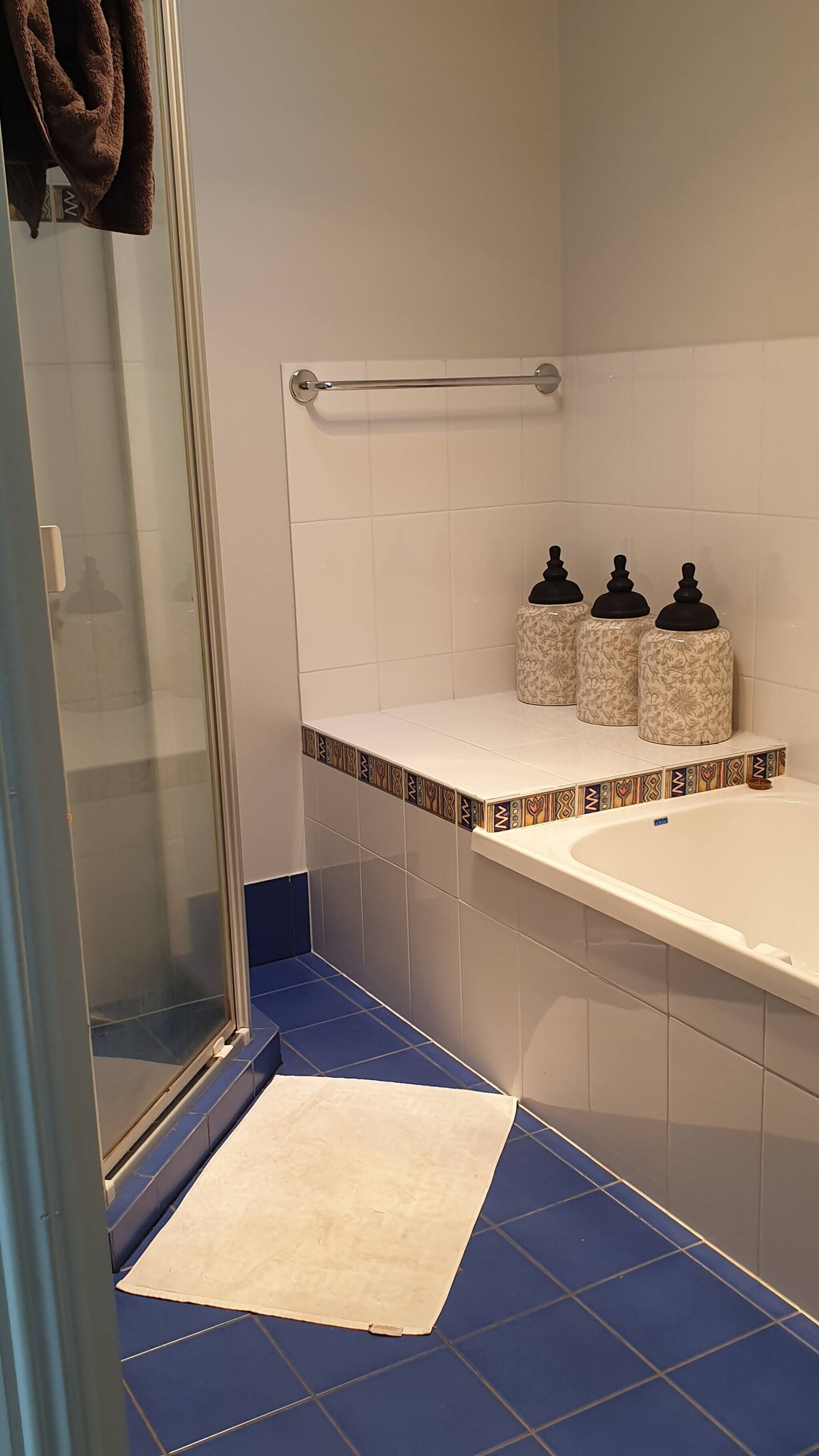 Ein Badezimmer mit Dusche, Badewanne und Handtuchhalter.
