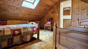 A wooden room with two beds, a skylight, and a wooden floor. - Gîte des Chênes, located in the heart of Béarn. (Arthez-de-Béarn)