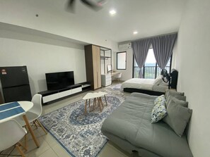 Una habitación de hotel moderna con cama, escritorio, televisión y balcón con cortinas.