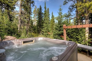 Un bain à remous entouré d’une forêt.