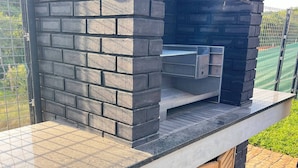 A brick-built outdoor kitchen with a countertop and a built-in grill. - Zimbali Lakes Boulevard Edge 214 (Ballito)