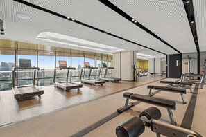 Ett modernt gym med löpband, bänkar och styrketräningsutrustning.