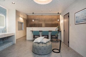A modern bathroom with a marble countertop, a round ottoman, and a wooden panel wall. - JAPAVISTA Zen (YOSHINO, FUKUSHIMA WARD)