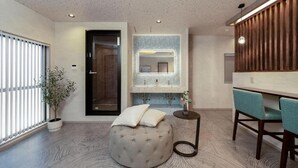 Een moderne badkamer met een rond poefje, een spiegel en een wastafel.