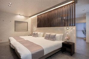 A modern hotel room with a large bed, a wooden panel wall, a nightstand with a vase, and a window with blinds. - JAPAVISTA Zen (YOSHINO, FUKUSHIMA WARD)