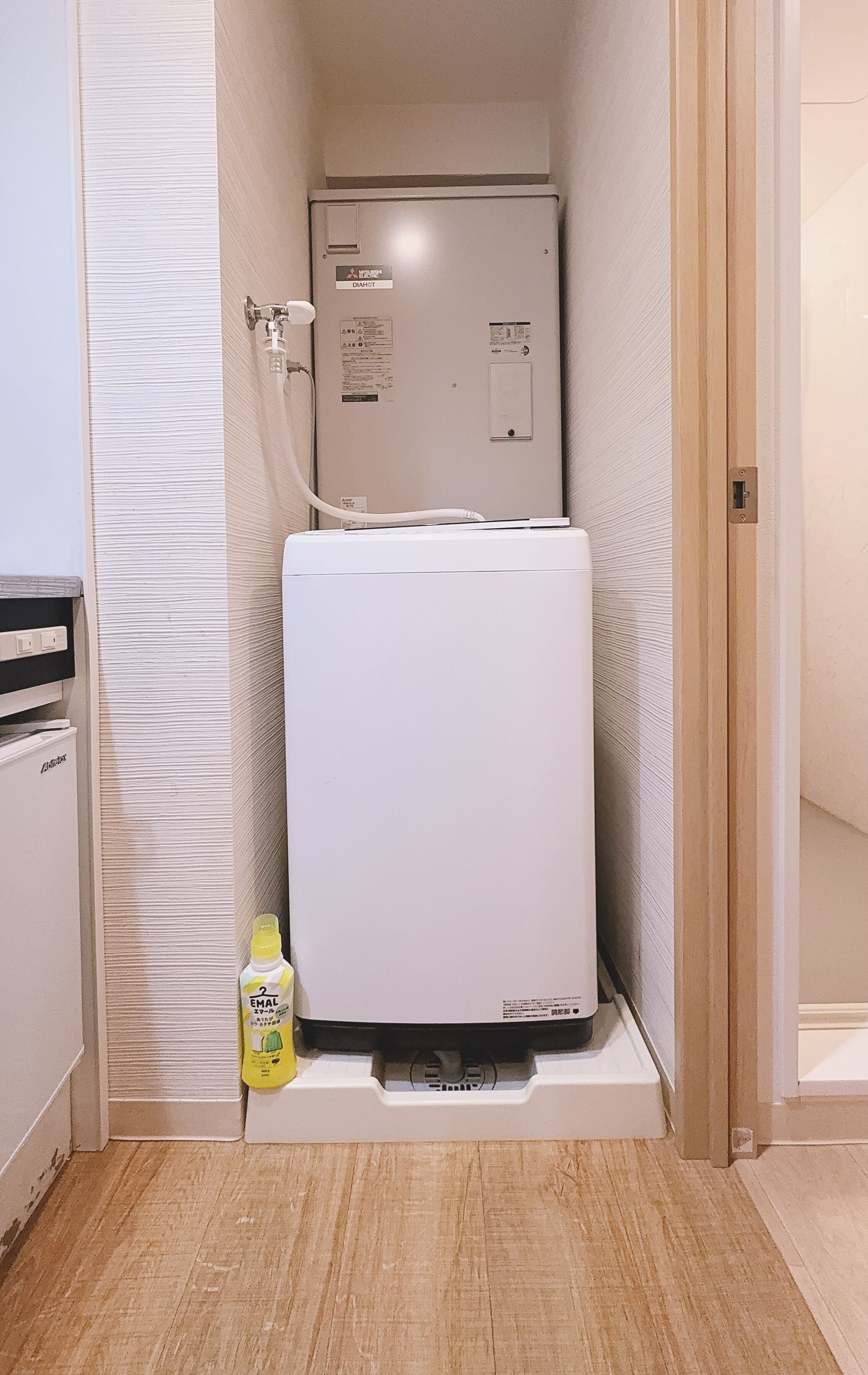 A compact room with a refrigerator, a water dispenser, and a small cabinet.